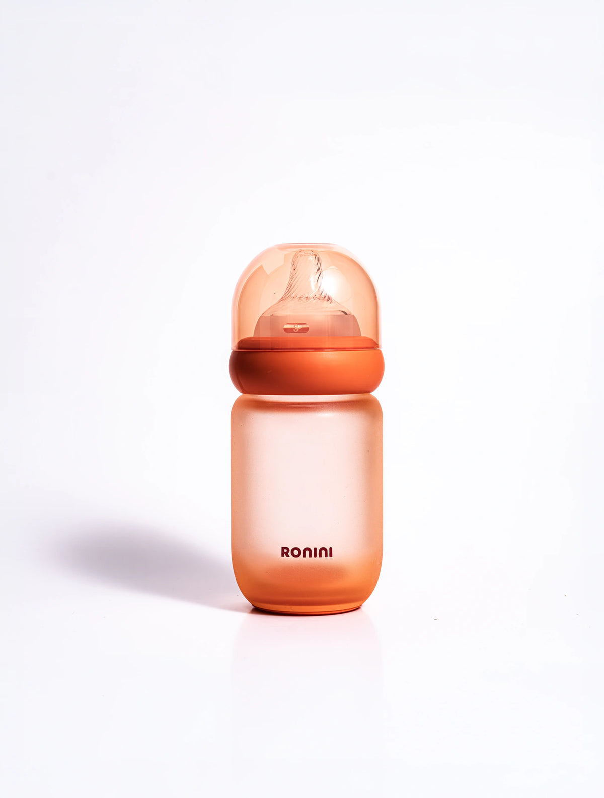 The Wrapped Glass Bottle, an orange glass baby bottle wrapped in silicone, 5 oz