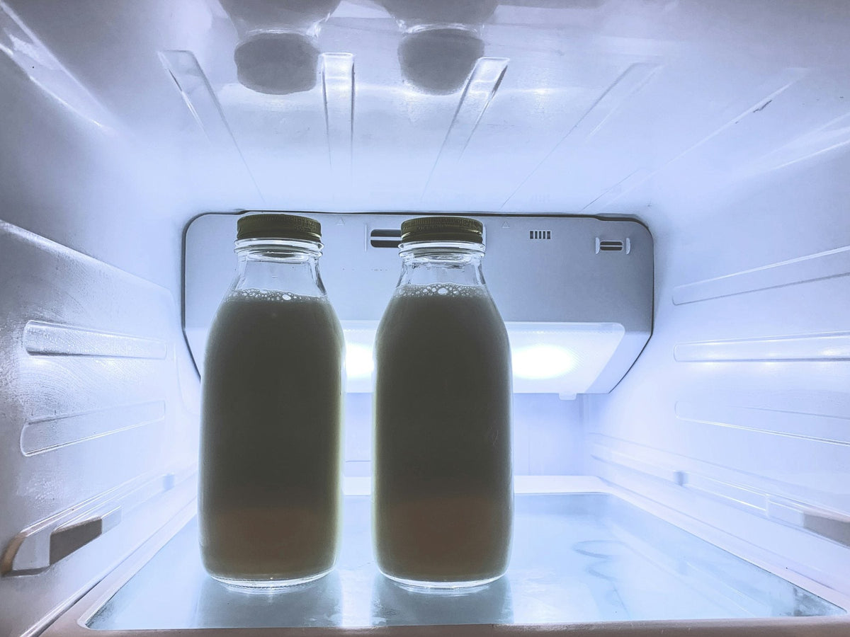 Two glass bottles of milk in the fridge
