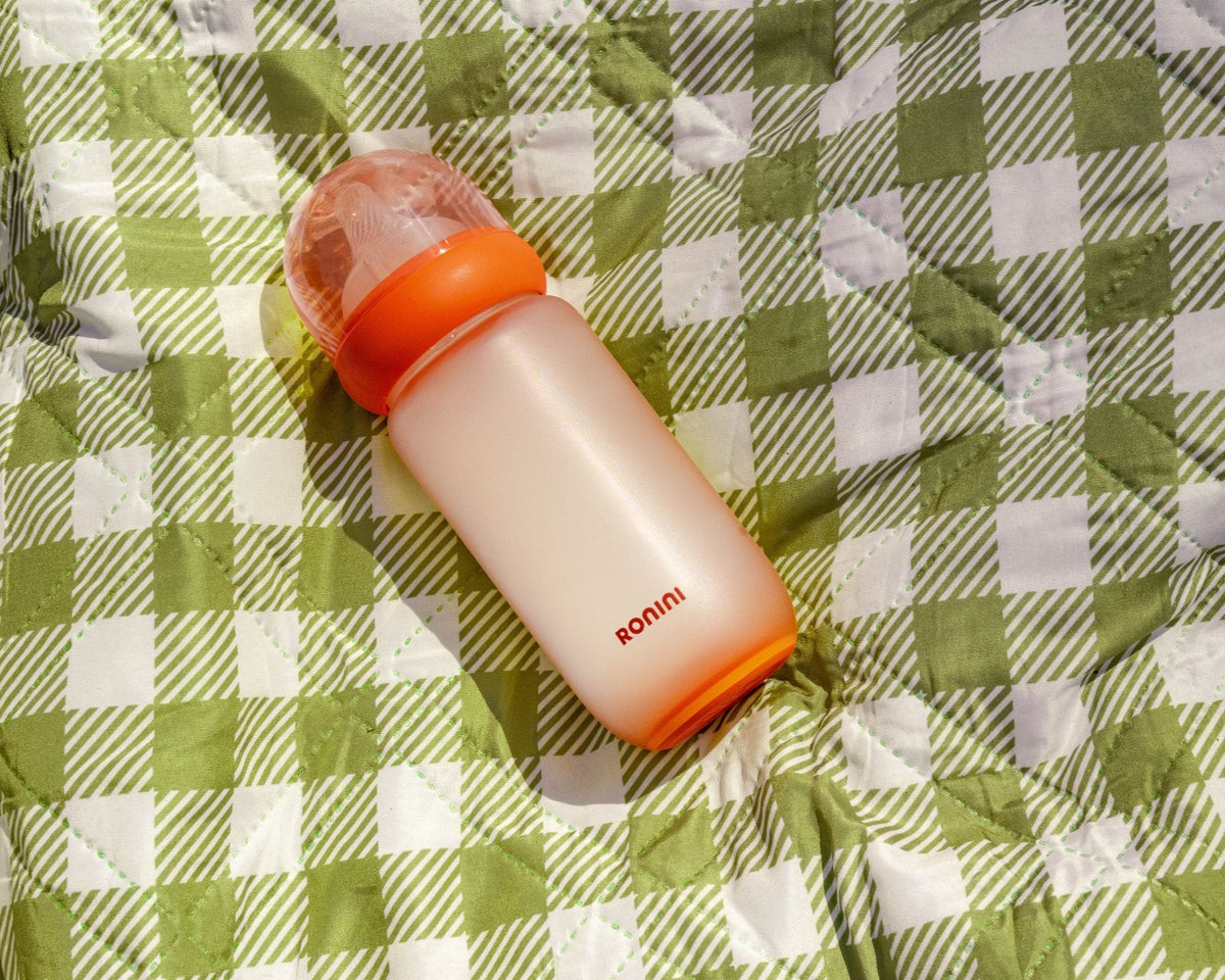 The Wrapped Glass Bottle on a green picnic blanket
